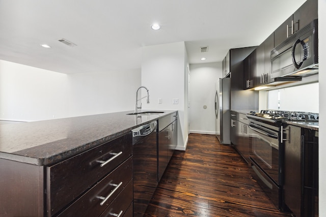 kitchen with black appliances, dark stone countertops, sink, and dark wood-type flooring