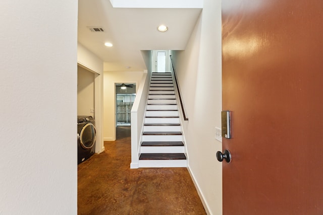 stairway featuring concrete flooring and washer / clothes dryer