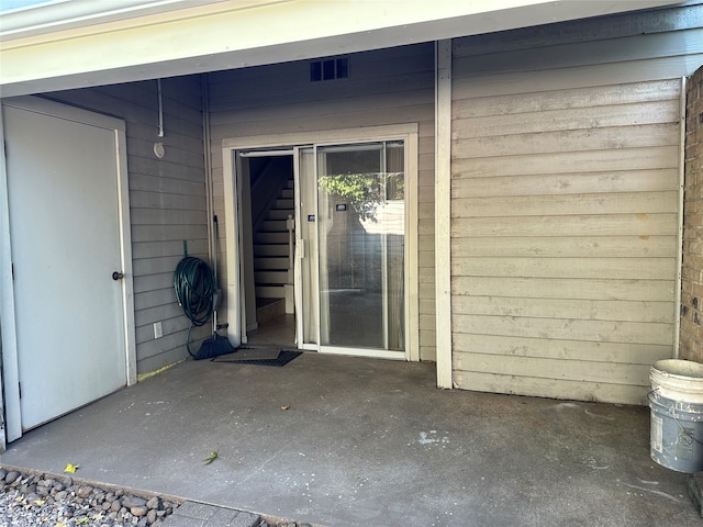 view of exterior entry with a patio