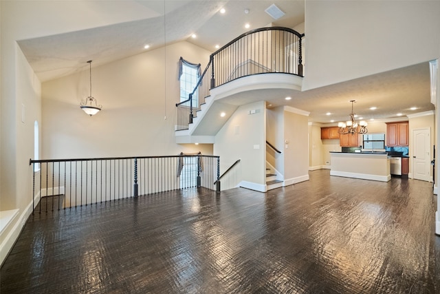 unfurnished living room featuring crown molding, a notable chandelier, high vaulted ceiling, and dark hardwood / wood-style flooring