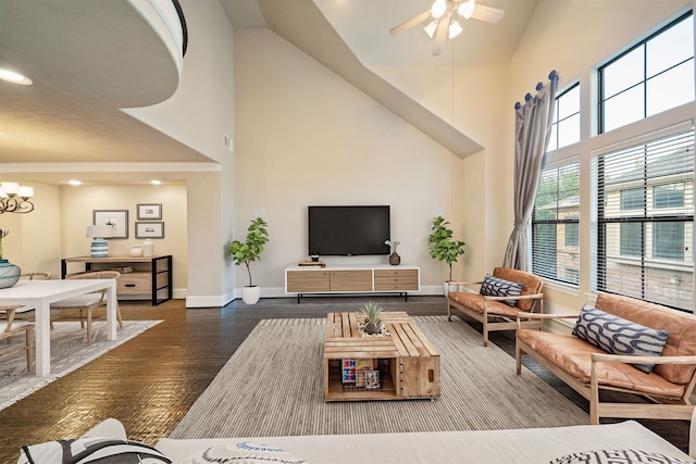 living room with hardwood / wood-style floors, ceiling fan with notable chandelier, and high vaulted ceiling