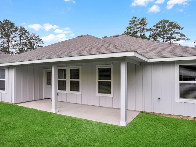 back of house with a patio and a lawn