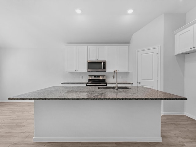 kitchen with a center island with sink, sink, appliances with stainless steel finishes, and white cabinetry