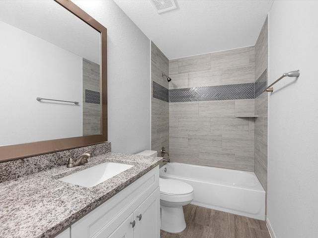 full bathroom featuring vanity, toilet, tiled shower / bath combo, and wood-type flooring