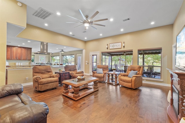 living room featuring a wealth of natural light, ceiling fan, and light wood-type flooring