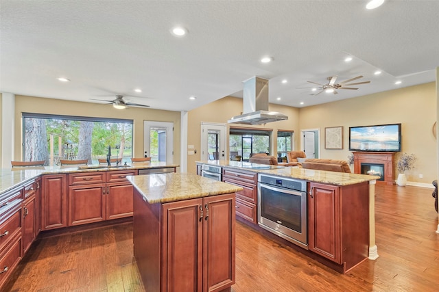 kitchen with a center island, stainless steel appliances, dark wood-type flooring, and island range hood