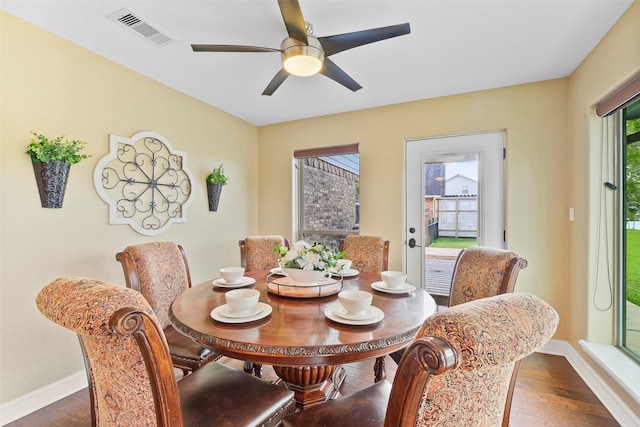 dining area with ceiling fan, a healthy amount of sunlight, and dark hardwood / wood-style flooring