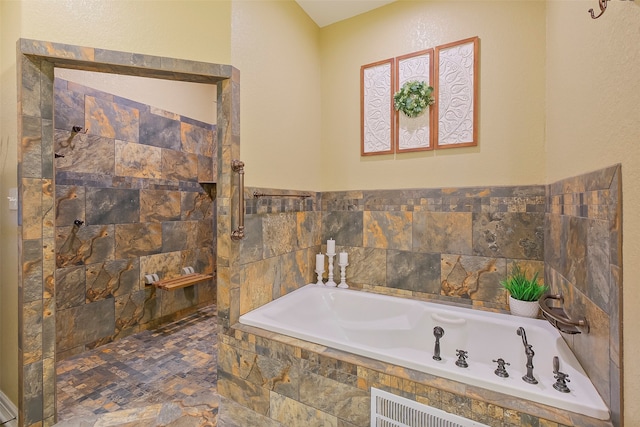 bathroom featuring a relaxing tiled tub