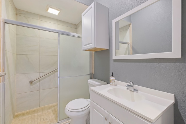 bathroom with a textured ceiling, vanity, an enclosed shower, and toilet