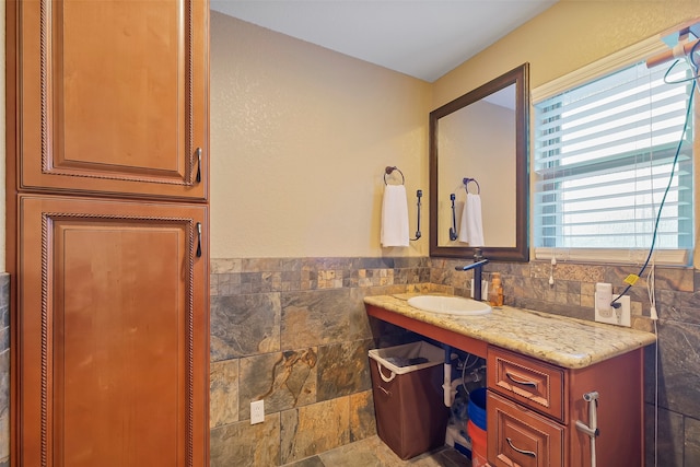 bathroom with vanity and tile walls