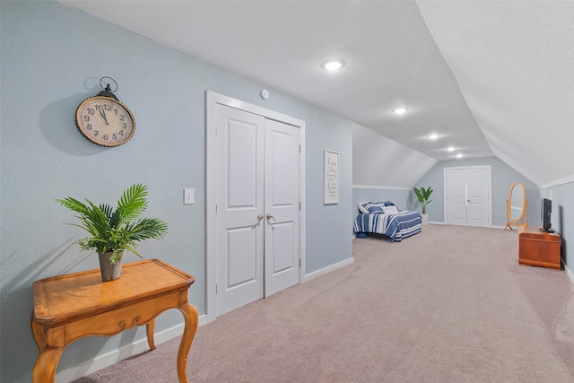 carpeted bedroom with lofted ceiling