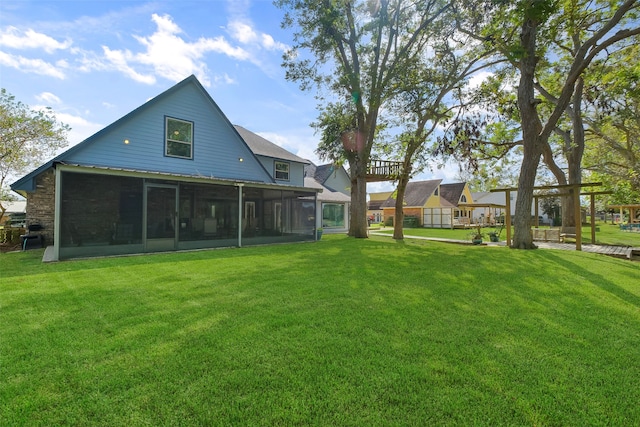 back of house featuring a lawn and a sunroom