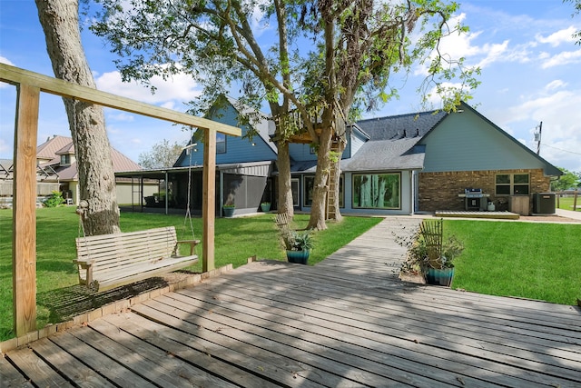 rear view of property featuring a deck and a lawn