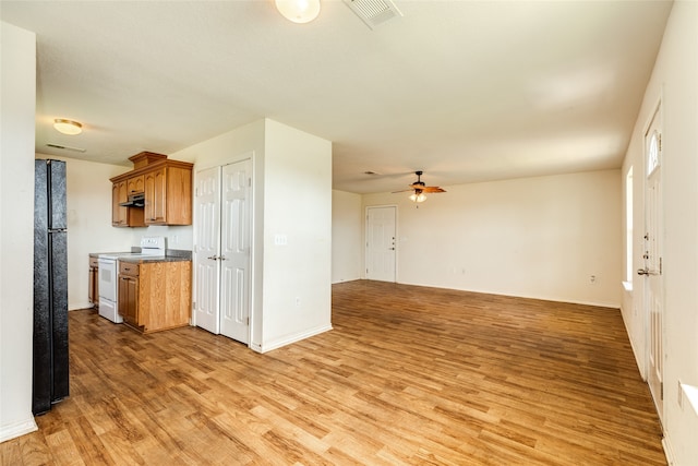 kitchen featuring ceiling fan, light hardwood / wood-style floors, white range with electric cooktop, and black refrigerator