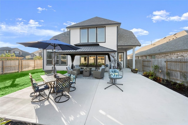 rear view of property with a patio area, an outdoor living space, and a yard