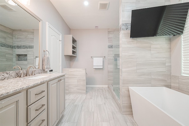 bathroom with vanity, tile walls, and separate shower and tub