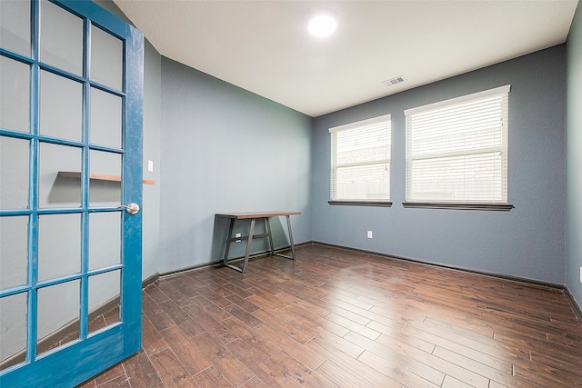 empty room with dark hardwood / wood-style flooring