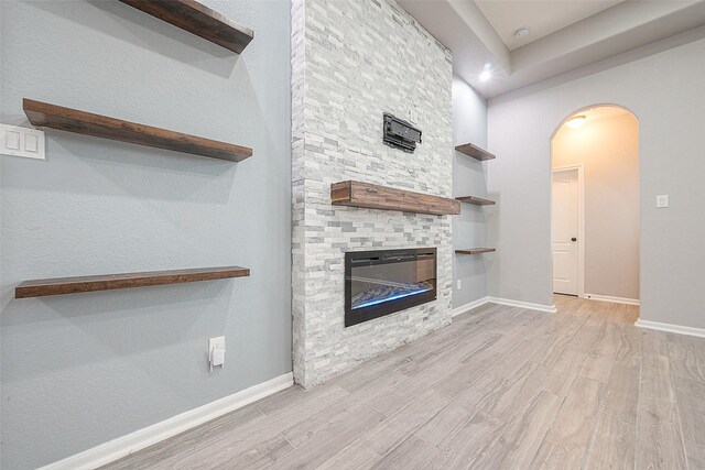 unfurnished living room with light wood-type flooring and a fireplace