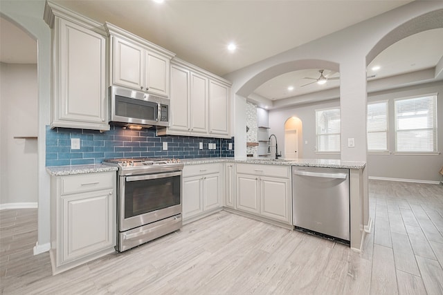 kitchen featuring white cabinets, ceiling fan, light hardwood / wood-style flooring, sink, and stainless steel appliances