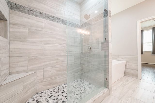 bathroom featuring tile walls and separate shower and tub