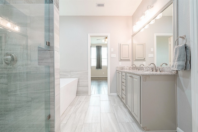 bathroom featuring vanity, independent shower and bath, and ceiling fan