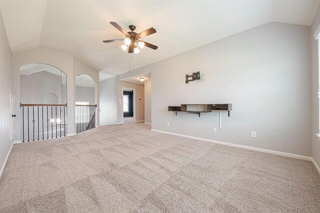 carpeted spare room featuring ceiling fan and lofted ceiling