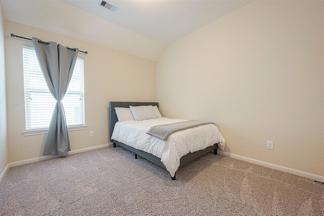 bedroom with vaulted ceiling, multiple windows, and carpet floors