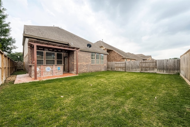 back of house with a patio area and a yard