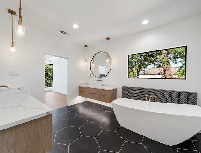 bathroom featuring vanity, a tub, and tile patterned flooring