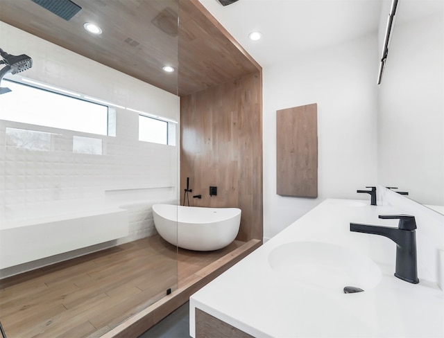 bathroom with vanity, hardwood / wood-style flooring, and independent shower and bath