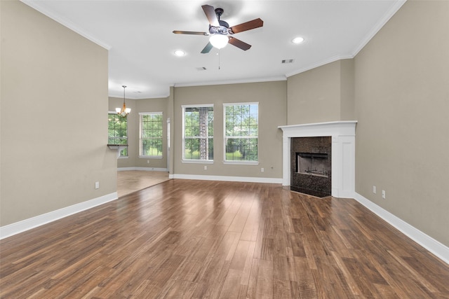 unfurnished living room featuring ceiling fan with notable chandelier, ornamental molding, and dark wood-type flooring