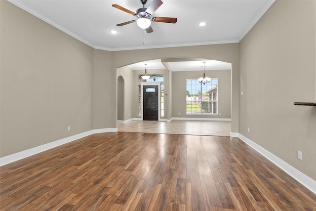 unfurnished living room featuring dark hardwood / wood-style floors, crown molding, and ceiling fan with notable chandelier