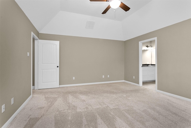 unfurnished bedroom featuring light carpet, ensuite bath, ceiling fan, and lofted ceiling