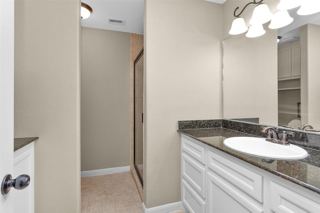 bathroom with tile patterned floors, a shower with door, and vanity