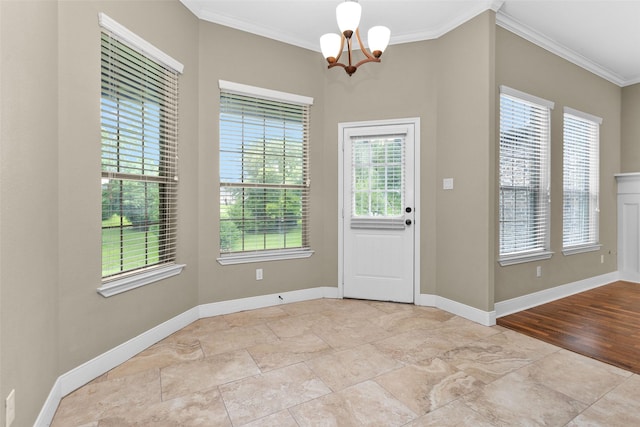 entryway featuring plenty of natural light, ornamental molding, and a chandelier