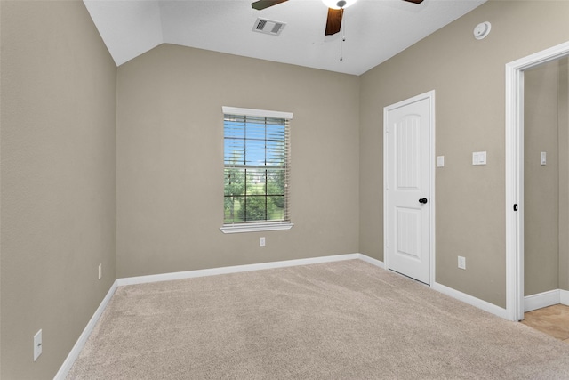 unfurnished room with ceiling fan, light carpet, and vaulted ceiling