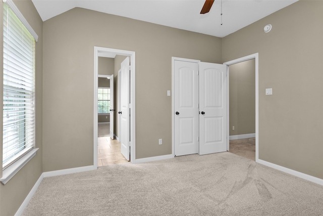 unfurnished bedroom with ceiling fan, light carpet, and a closet