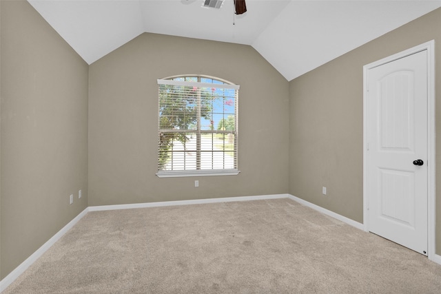 spare room featuring ceiling fan, light colored carpet, and vaulted ceiling