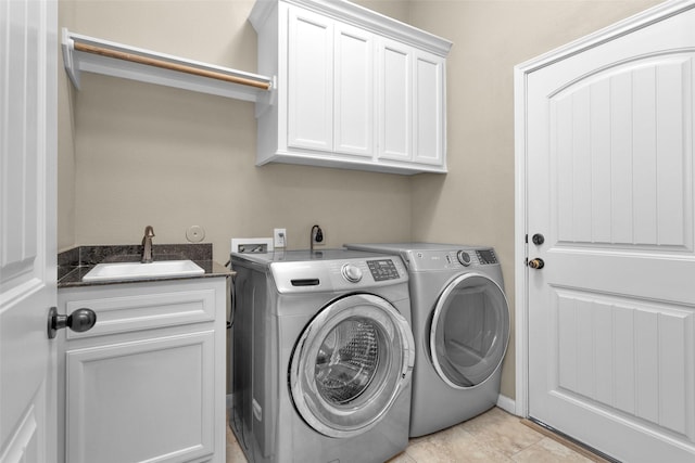 washroom with separate washer and dryer, sink, light tile patterned flooring, and cabinets