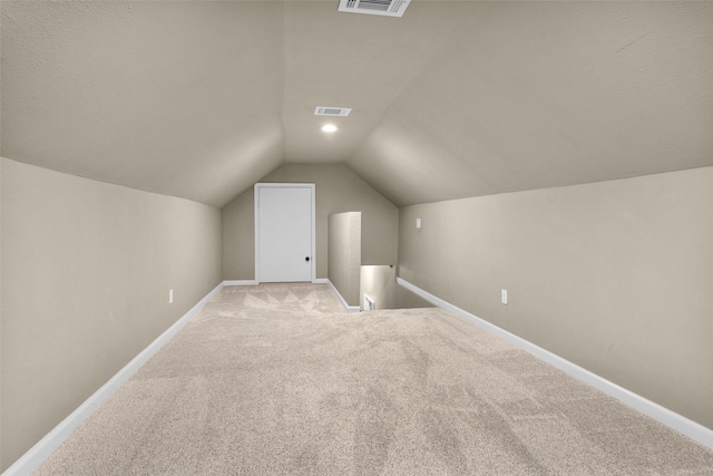 additional living space with light carpet and vaulted ceiling