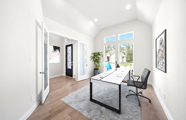 office featuring vaulted ceiling, light wood-type flooring, and french doors