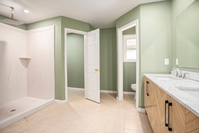 bathroom featuring toilet, walk in shower, vanity, and tile patterned flooring