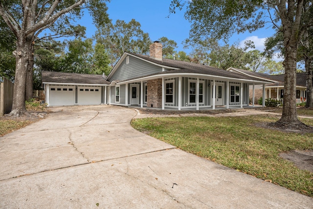 ranch-style home featuring a front yard, a garage, and a porch