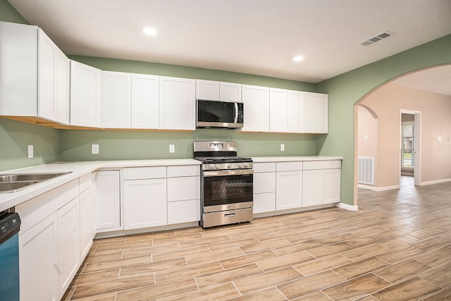 kitchen featuring stainless steel appliances, light wood-type flooring, and white cabinets