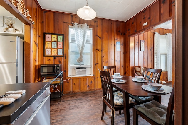 dining room with ornamental molding, wooden walls, cooling unit, and dark hardwood / wood-style floors