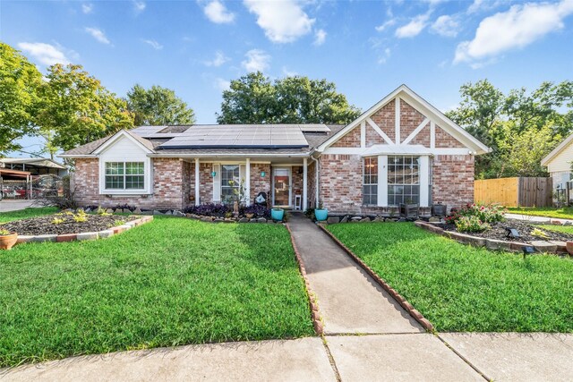 view of front of home featuring solar panels and a front lawn