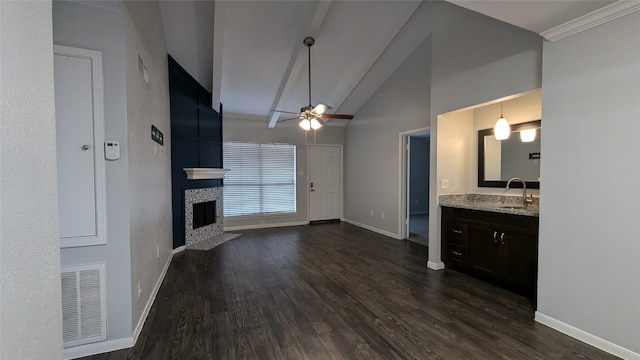 unfurnished living room with dark hardwood / wood-style flooring, ceiling fan, high vaulted ceiling, a fireplace, and sink