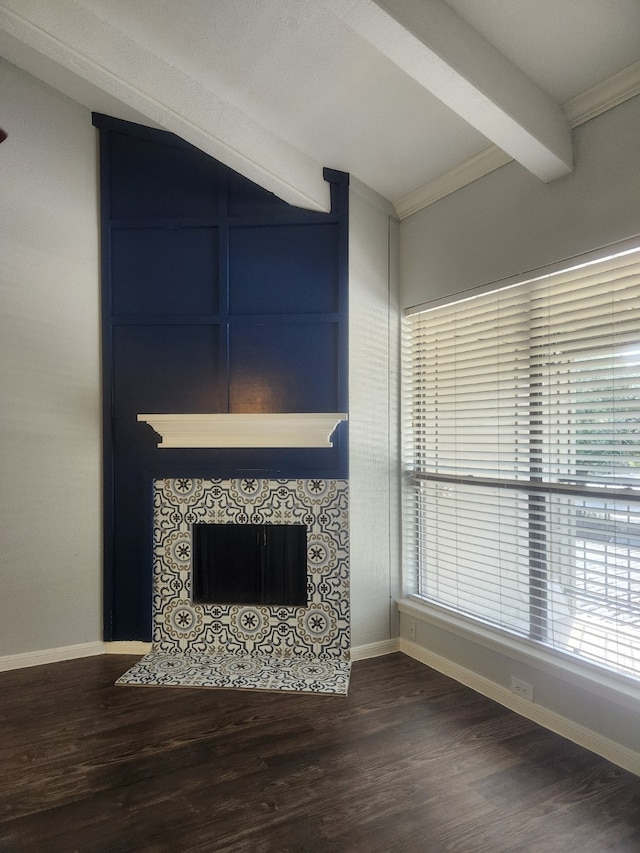 unfurnished living room featuring ornamental molding, beam ceiling, a fireplace, and dark hardwood / wood-style flooring