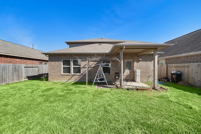 back of house featuring a patio area and a lawn