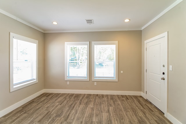 foyer entrance featuring crown molding and hardwood / wood-style floors